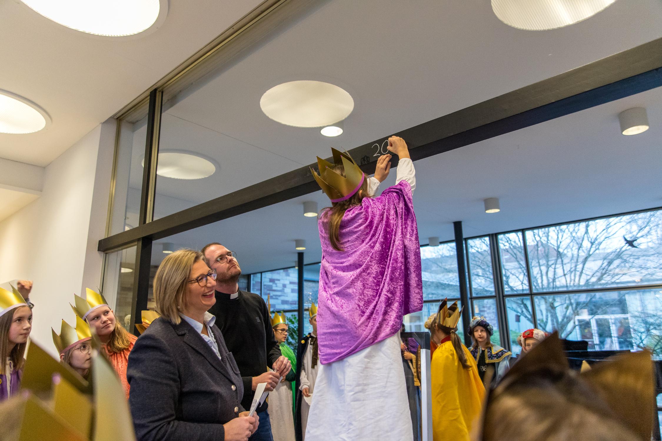 Louisa (9) aus Nunkirchen schreibt den Segen an.